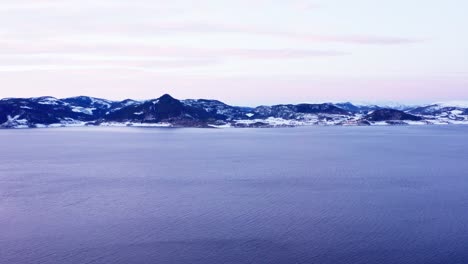 Serene-Water-Of-Norwegian-Sea-With-Mountain-Landscape-In-The-Distance-At-Winter
