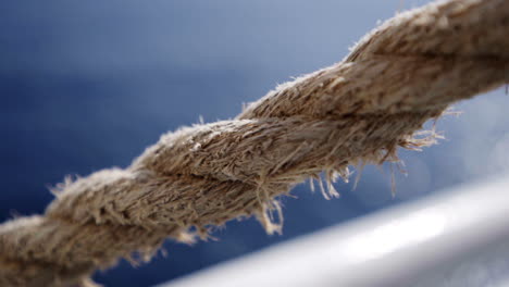 Close-up-gimbal-shot-of-ferry-rope,-bright-ocean-in-background