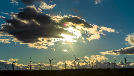 Windmills-generating-efficient-and-clean-energy-with-the-sun-setting-and-a-colorful,-golden-cloudscape---wide-angle-time-lapse