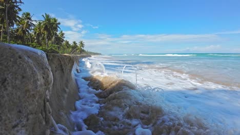 Foamy-wave-runs-up-and-crash-into-sandy-wall
