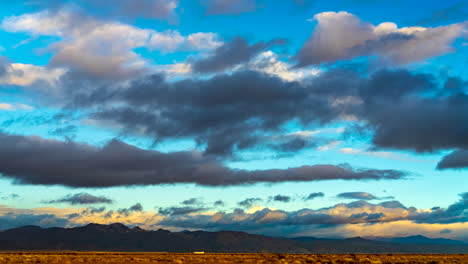 Farbenfrohe-Wolkenlandschaft-über-Der-Mojave-Wüstenlandschaft-Und-Schroffen-Bergen-Bei-Sonnenuntergang---Weitwinkel-Zeitraffer