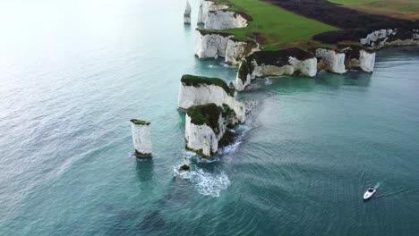 Drone-shot-of-Old-Harry-Rocks-with-a-boat-in-the-Isle-of-Purbeck,-England