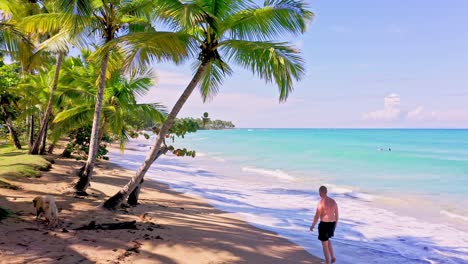 Caucasian-Man-Walking-In-Quiet-Beach-In-Playa-Bonita,-Dominican-Republic---wide-shot