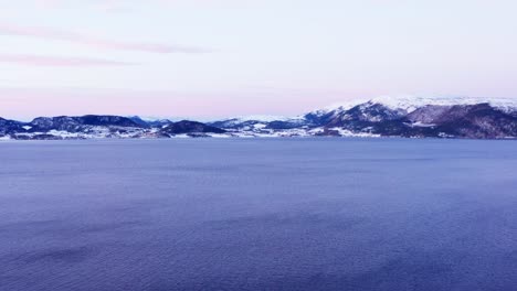 Stunning-Norwegian-Countryside-With-Calm-Fjord-And-Snow-capped-Mountains-In-Winter