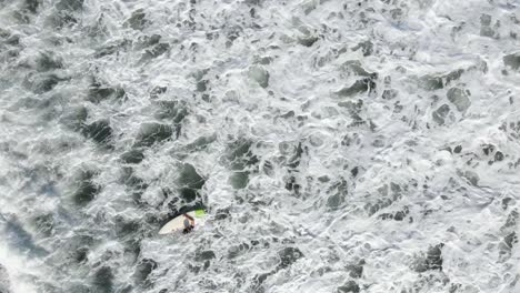 AERIAL---Looking-straight-down-on-surfer-waiting-to-catch-a-wave