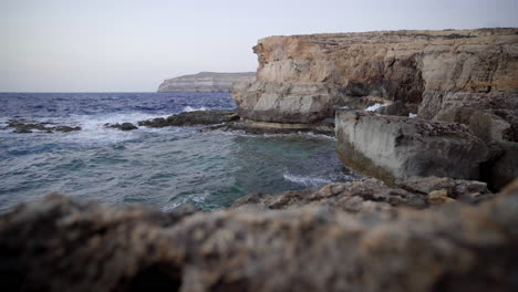 Sea-waters-hitting-rocky-cliff,-Gozo-island