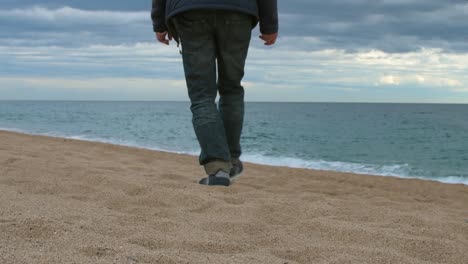 Blick-Auf-Die-Beine-Eines-Erwachsenen-Mannes,-Der-Am-Strand-In-Richtung-Meer-Geht