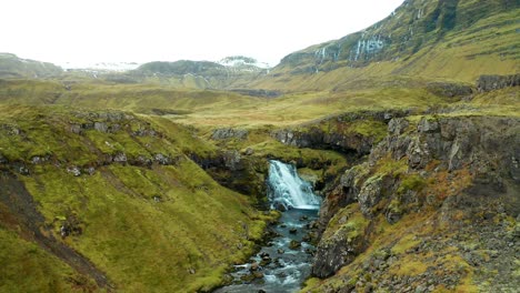 Cinematic-landscape-in-Iceland-mountain-valley-with-a-river-and-a-waterfall,-near-Kirkjufellsfoss-and-Kirkjufell