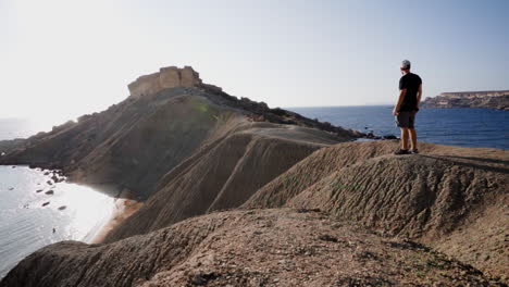 Caucasian-tourist-contemplating-huge-dunes-cliffs-in-Malta-island