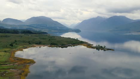Zeitlupenaufnahme-Des-Wunderschönen-Szenarios-Der-Leeren-Insel-In-Der-Nähe-Der-Bergkette-Am-Abend-Vor-Einem-Natürlichen-Hintergrund-Von-Glen-Coe,-Loch-Etive-In-Schottland