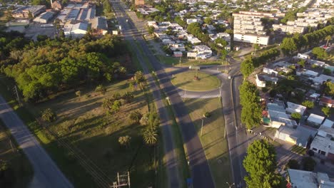 Aerial-shot-of-Green-truck-by-roundabout-at-sunset-at-Colonia-del-Sacramento-in-Uruguay