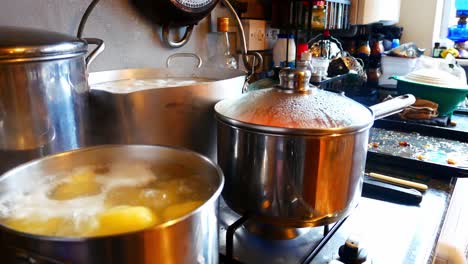 Silver-pots-cooking-Christmas-food-on-hot-gas-stove-in-family-kitchen-preparing-dinner-lowering-wide-right-jib-shot