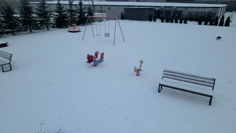 Luftbild-Eines-Hundes,-Der-Im-Winter-Auf-Einem-Verschneiten-Spielplatz-In-Lubawa,-Polen,-Spaziert