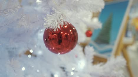 Tracking-into-Christmas-bobble-on-white-plastic-Christmas-tree