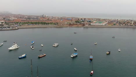 Drone-shot-of-Callao-district-shoreline-with-parked-boats-and-ships-in-Peru