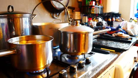 Silver-pots-cooking-Christmas-food-on-hot-gas-stove-in-family-kitchen-preparing-dinner-wide-rising-jib-left
