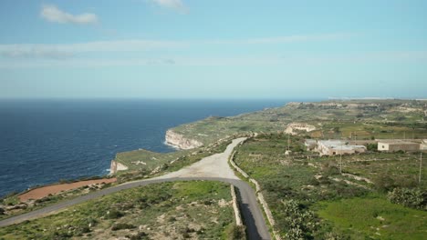 AERIAL:-Flying-Over-Road-On-Dingli-Cliffs-with-Mediterranean-Sea-in-the-Background-on-Sunny-Day