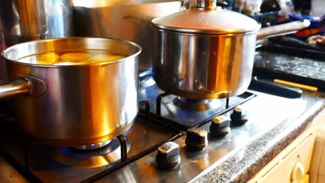 Silver-pots-cooking-Christmas-food-on-hot-gas-stove-in-family-kitchen-preparing-dinner-rising-dolly-left
