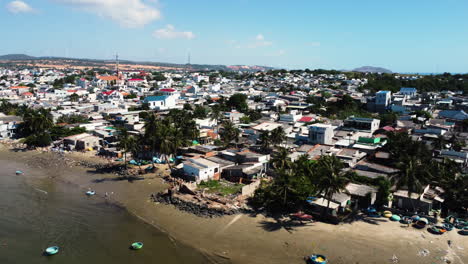 Coiffed-trees-on-historic-coconut-jungle-Vietnam-makes-place-for-polluted-beach-dirty-boats,-and-life-in-vietnamese-countyside,-Backwards-drone-dolly-shot