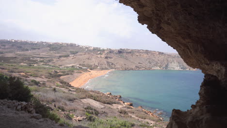 Dolly-left-shot-of-Ramla-Bay-seen-from-Tal-Mixta-Cave,-Gozo