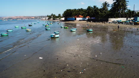 Barcos-De-Coracle-Vietnamitas-Tradicionales-Redondos-Flotan-En-La-Orilla-De-La-Playa-Sucia-Y-Contaminada