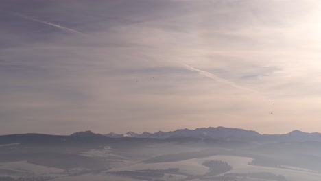 Weit-Offener-Blick-Auf-Die-Bergkette-Im-Winter-Mit-Heißluftballons