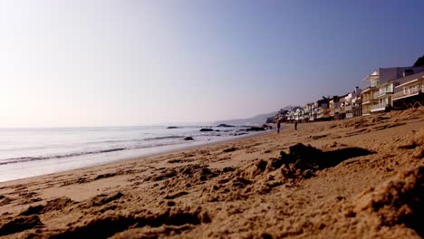 Time-lapse-of-people-walking-at-the-beach-in-Malibu-on-a-resitendial-area