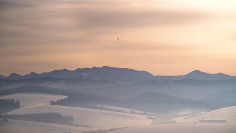 Heißluftballon-über-Einer-Unglaublichen,-Silhouettierten-Winterberglandschaft-Bei-Sonnenuntergang