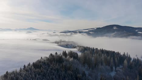 Atemberaubender-Flug-über-Verschneite-Winterlandschaft-Mit-Wolken-Und-Bergen