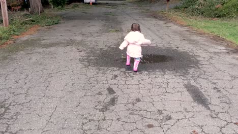 Chasing-after-a-cute-little-girl-as-you-splashes-in-a-tiny-puddle