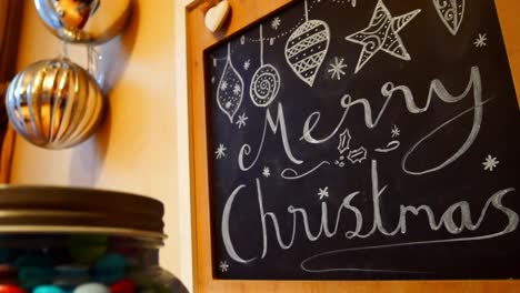 Frohe-Weihnachten-Und-Kugeln-Dekoration-Handgezeichnet-Auf-Kreidetafel-Hängend-An-Der-Küchenwand-Dolly-Rechts