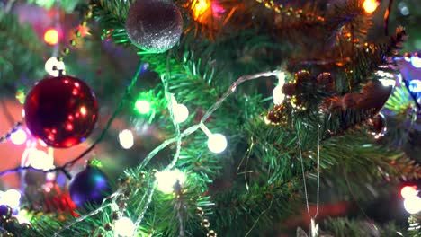 Close-up-tilt-down-over-colorful-Christmas-tree-with-decorations-and-lights