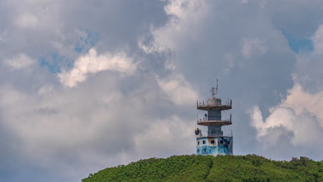 Old-telecommunications-tower-on-a-hilltop-near-Noumea,-New-Caledonia---time-lapse-with-dynamic-cloudscape