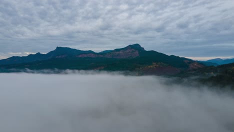 Low-fog-clears-and-reveals-Cape-Horn-along-the-Columbia-River-Gorge,-aerial-hyperlapse