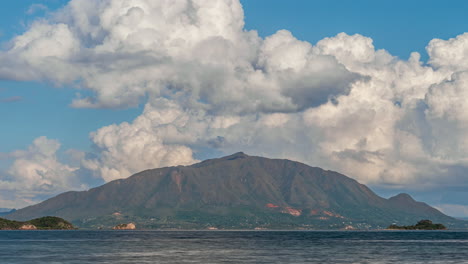 Der-Berühmte-Berggipfel-Mont-Dore-In-Neukaledonien,-Wie-Er-Von-Der-Anderen-Seite-Der-Bucht-Aus-Gesehen-Wird,-Mit-Riesigen-Kumuluswolken,-Die-Sich-über-Der-Insel-Bilden-Und-Auflösen---Zeitraffer