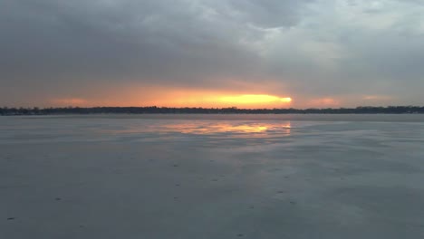 A-Frozen-lake-on-a-winter-cloudy-afternoon-during-sunset,-Bde-Maka-Ska-lake-in-Minneapolis