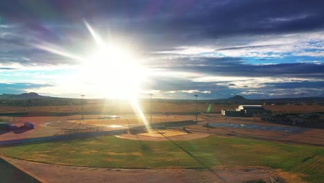 Parque-De-Béisbol-Con-El-Paisaje-Del-Desierto-De-Mojave-En-El-Fondo-En-Una-Tarde-Soleada-Brillante---Retroceso-Aéreo