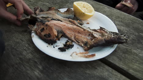 Grilled-fish-outdoors-eating-with-hands