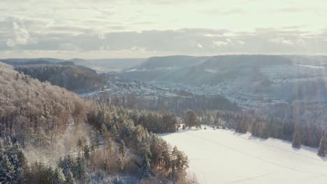 Aerial-4K-winter-footage-panning-right-over-a-snow-covered-landscape