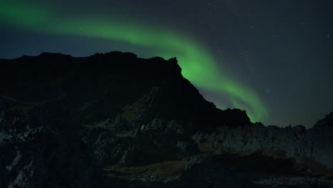 Mesmerizing-dance-of-the-northern-lights-in-the-starry-sky-above-the-dark-silhouettes-of-the-jagged-rocks