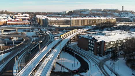 Urban-Highway-Intersection-With-Elevated-Railroad-With-Train,-Downtown-Gothenburg-at-Winter,-Sweden,-Aerial