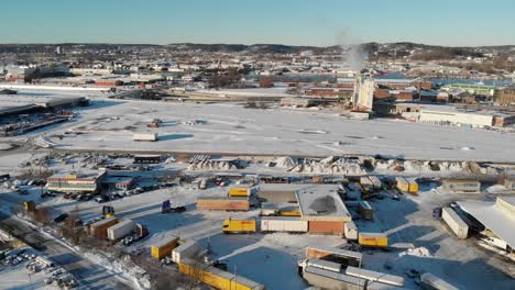 Cityscape-with-Trucks-at-an-Industrial-Area,-Gothenburg,-Snow-Covered,-Sweden,-Aerial