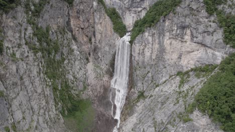 Video-of-a-bird's-eye-view-drone-backing-up-in-front-of-the-Boka-waterfall-in-Slovenia