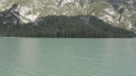 Side-view-drone-video-"slider"-over-Italy's-lago-di-landro-durrensee-with-mountains-on-the-horizon