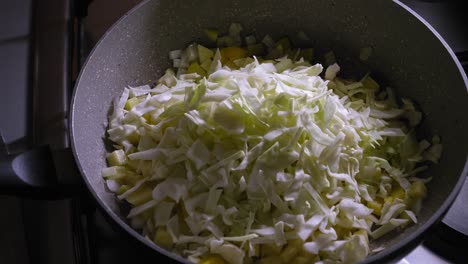 Cabbage-Is-Added-To-Simmering-Pot-With-Vegetarian-food,-Cooking-Veggie-Eggs-With-Cheese---Steady-Shot