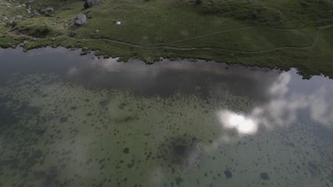 Descriptive-frontal-plane-drone-video-over-Lake-Valparola-with-mountains-on-the-horizon-in-the-Valparola-pass