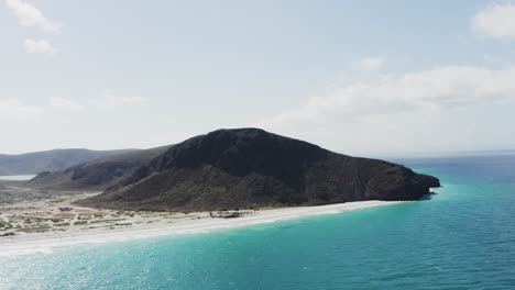 A-drone-rises-over-blue-water-of-Tecolote-Beach,-Baja-Mexico