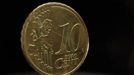 Close-up-of-a-10-euro-cent-coin-with-a-black-background-that-is-spinning