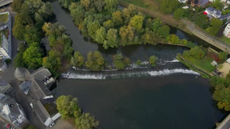 Overflow-man-made-waterfall-on-river-Lahn-in-Hesse-city,-aerial