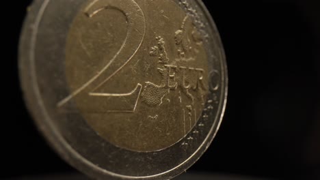 Nahaufnahme-Einer-2-Euro-Münze-Mit-Schwarzem-Hintergrund,-Die-Sich-Dreht